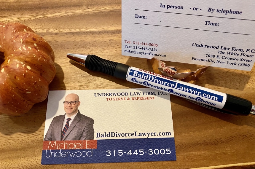 A pen and business card on top of a table.